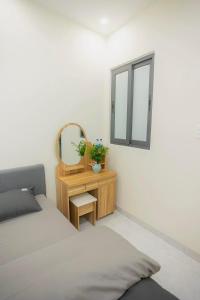 een slaapkamer met een bed, een spiegel en een tafel bij Amy Hotel & Apartment in Da Thanh