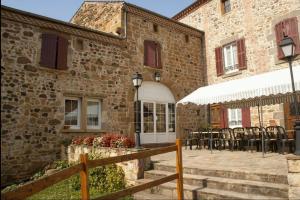 a building with a patio with tables and chairs at Chambre Château in Augnat