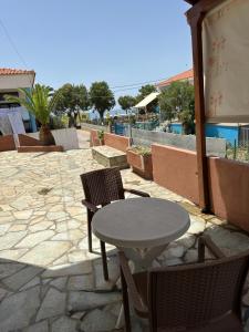 a table and chairs sitting on a patio with a table at Joanna Rooms in Skala Eresou