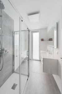 デセンツァーノ・デル・ガルダにあるNeue Penthouse Wohnung mit Whirlpool und Garageのシャワーと洗面台を備えた白いバスルーム