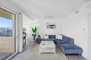 デセンツァーノ・デル・ガルダにあるNeue Penthouse Wohnung mit Whirlpool und Garageの青いソファとテーブルのあるリビングルーム