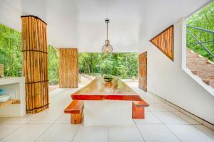 a dining room with a table and a large window at Antema Lodge Secteur Tamarindo, piscine, yoga, gym, jungle et paix in Tamarindo