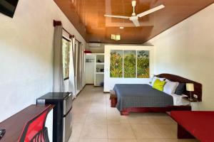 a bedroom with a bed and a ceiling fan at Antema Lodge Secteur Tamarindo, piscine, yoga, gym, jungle et paix in Tamarindo