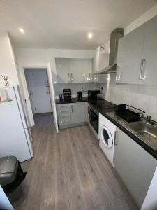 a kitchen with a sink and a washing machine at Luxe Apartment in Croydon