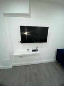 a flat screen tv hanging on a white wall at Luxe Apartment in Croydon