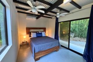 a bedroom with a bed and a ceiling fan at Antema Lodge Secteur Tamarindo, piscine, yoga, gym, jungle et paix in Tamarindo +185 photos