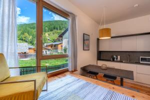 a living room with a table and a large window at Quercus Appartements contactless check-in in Patergassen