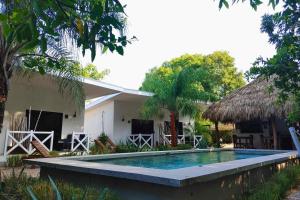 a swimming pool in front of a house at Antema Lodge Secteur Tamarindo, piscine, yoga, gym, jungle et paix in Tamarindo