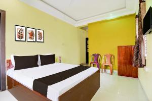 a bedroom with a bed and two chairs at Hotel O TARA in Jojera