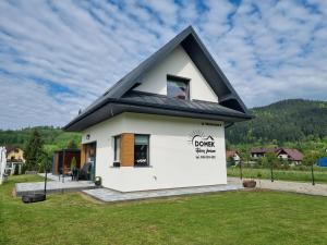 クロシチェンコにあるDomek Otulony Słońcemの黒屋根の小さな白い家