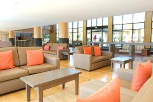 een lobby met banken, tafels en ramen bij The Navigator - Colombus All Inclusive in Porto Santo