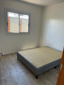 een bed in een kamer met een raam bij Porfiado in La Paloma