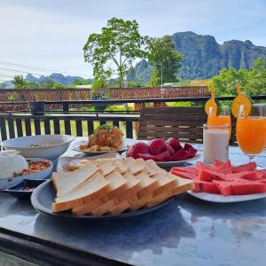 Una mesa con platos de comida y bebidas sobre ella. en vangvieng SCK Hotel, en Vang Vieng