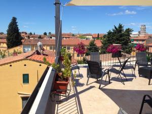 a patio with chairs and plants on a roof at Hotel Di Stefano in Pisa