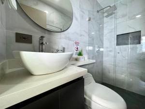 a bathroom with a sink and a toilet and a mirror at Torre Zurich Luxury in Medellín +43 photos