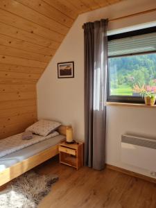 クロシチェンコにあるDomek Otulony Słońcemのベッドと窓のある寝室