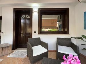 a room with two chairs and a door with a mirror at Casa Baronia in Assemini