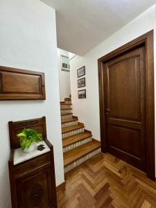a hallway with a wooden door and stairs at Casa Baronia in Assemini