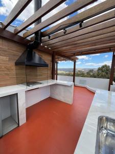 eine offene Küche mit Holzdecken und rotem Bodenbelag in der Unterkunft Casa com ar condicionado, churrasqueira e rooftop in Alto Paraíso de Goiás