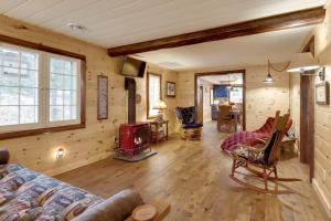 a living room with wooden walls and a woodburning stove at Peaceful Nature Escape on Little Portage Lake! in Land O' Lakes