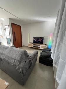 ein Wohnzimmer mit einem Bett und einem Fernseher in der Unterkunft Casa com ar condicionado, churrasqueira e rooftop in Alto Paraíso de Goiás + 41 Fotos