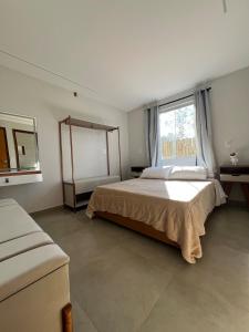 ein Schlafzimmer mit großem Bett und Fenster in der Unterkunft Casa com ar condicionado, churrasqueira e rooftop in Alto Paraíso de Goiás