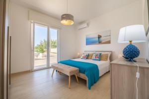 a bedroom with a bed and a table with a lamp at Villa Palibella in Torre Pali  +34 photos