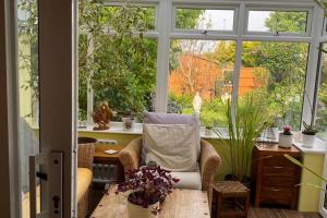 a room with a chair and a table and a window at 2-Bed House Sleeps 4 - Enclosed Garden - Tv & WiFi in Amesbury