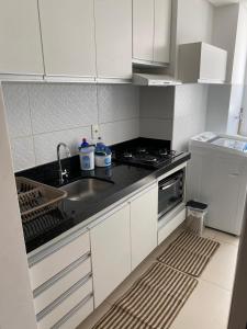 Una cocina blanca con fregadero y estufa. en Mirante, en Parnamirim 11 fotos más