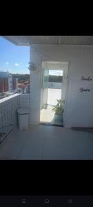 a white room with a window and a plant at Quarto Aconchegante in João Pessoa