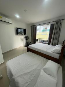 Duplex Castellana 62 Norte Monteria AA في مونتيريا: سريرين في غرفة فندقية بها نافذة