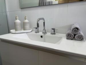 a bathroom sink with two bottles of soap and towels at Delamere Farm Stay in Delamere +9 photos