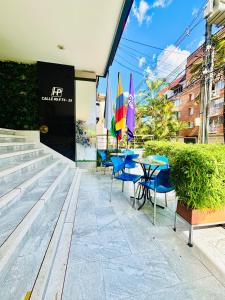 a patio with blue chairs and tables and umbrellas at Hotel Laureles Plaza in Medellín