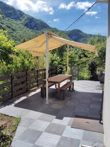 a wooden bench under a canopy on a patio at petite maison sans vis a vis in Thoirette