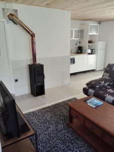 a living room with a couch and a stove at petite maison sans vis a vis in Thoirette +4 photos