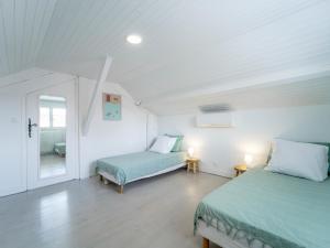 a white room with two beds and a window at Maison rénovée à Mimizan pour 10 pers. avec jardin proche océan - FR-1-50-194 in Mimizan