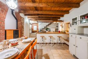 a kitchen with wooden ceilings and a counter with stools at Romeos Cottage Public free parking bike rental in Verona