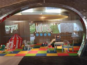 a childrens play room with a table and a playground at Stay with me by Veranda Resident in Na Jomtien