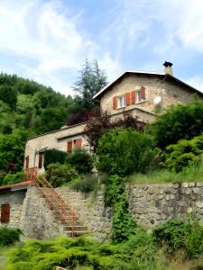 a house on top of a stone wall at La Bergerie De L'aulagner in Saint-Barthélemy-le-Meil