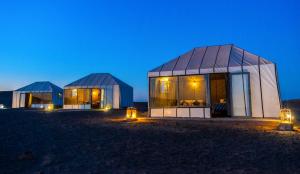 two domed buildings in the desert at night at Typical Luxury Desert Camp in Merzouga