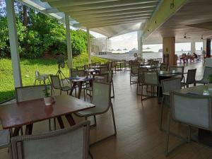 a restaurant with tables and chairs and people walking around at Stay with me by Veranda Resident in Na Jomtien