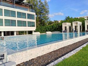 a swimming pool in front of a building at Stay with me by Veranda Resident in Na Jomtien