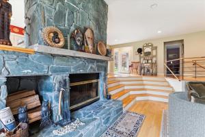 a living room with a large stone fireplace at Raven's Nest in Stowe