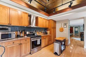 a kitchen with wooden cabinets and a stove top oven at Raven's Nest in Stowe