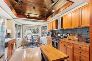 a kitchen with wooden cabinets and a wooden table at Raven's Nest in Stowe +31 photos