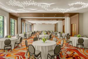 a banquet hall with white tables and chairs and chandeliers at Renaissance Atlanta Midtown Hotel in Atlanta