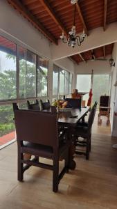 a dining room with a table and chairs and windows at MountainzenEscape in Los Altos de Cerro Azul +25 photos