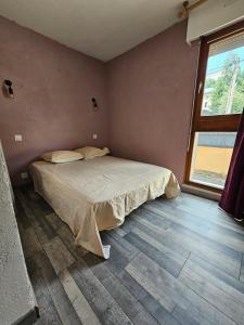 ein Schlafzimmer mit einem Bett und einem großen Fenster in der Unterkunft Cozy 1-room apartment with veranda and parking in Font-Romeu