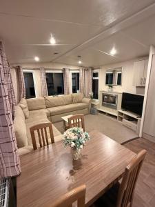タターズホールにあるTattershall Caravan- 28 The Pasturesのテーブルとソファのあるリビングルーム