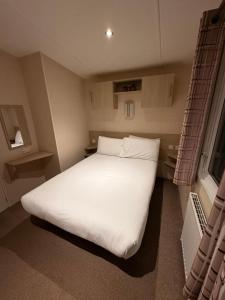 タターズホールにあるTattershall Caravan- 28 The Pasturesの小さな部屋にある大きな白いベッド +12枚の写真